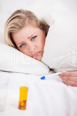 Sick young woman holding a thermometer