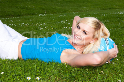 Beautiful blonde with lovely smile on grass