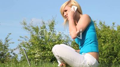 Young blonde woman outside on the phone