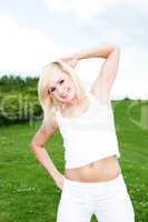 Woman exercising in green field