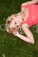 Smiling sexy blonde relaxing on grass