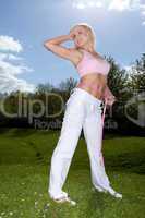 Fit young blonde woman measuring her waist