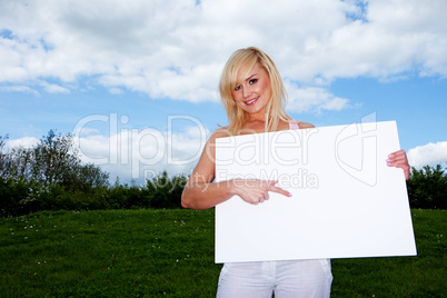 Blonde woman holding empty sign outside