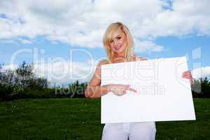 Blonde woman holding empty sign outside