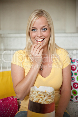 young woman eats popcorn