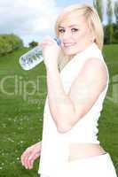 Young blonde drinking water outside