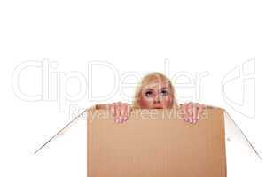 Scared young blonde emerging from a box