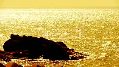 Sparkling water surface and rock reef coastal,horizon,skyline,sunrise,Gold.