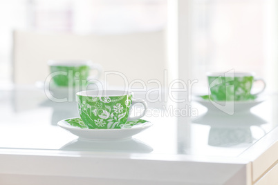 three cups of tea on a glass table