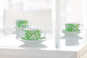 three cups of tea on a glass table