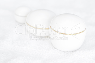 cosmetic containers lying on white towel