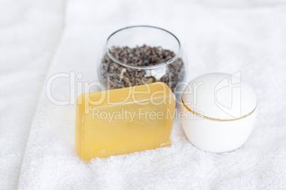 cosmetic containers, soap and lavender on a white towel