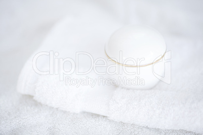 cosmetic containers lying on white towel