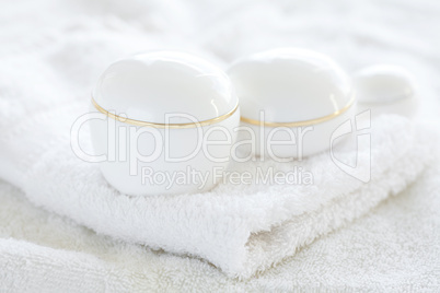 cosmetic containers lying on white towel