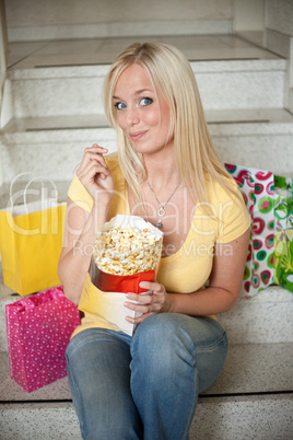 young woman eats popcorn