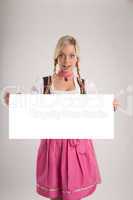 woman with dirndl holds empty signboard