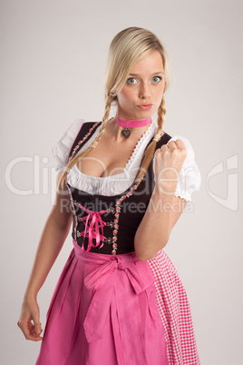 woman with dirndl warns with fist
