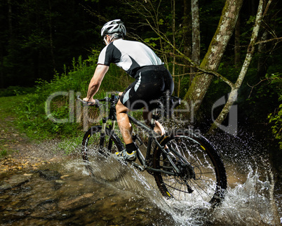 Mountainbiker durchquert einen Bach