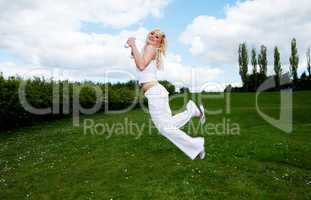 Pretty young blonde jumping outside