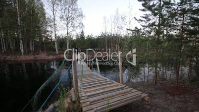 Bicyclist Rides over the Bridge in the Forest