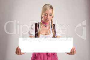 woman with dirndl holds an empty signboard