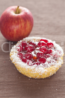 beautiful cake with berries and apple on brown mat