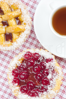 beautiful cake with berries and tea on plaid fabric