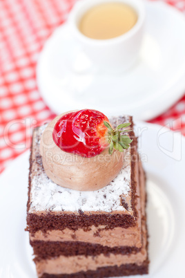 beautiful cake with strawberry and tea on plaid fabric