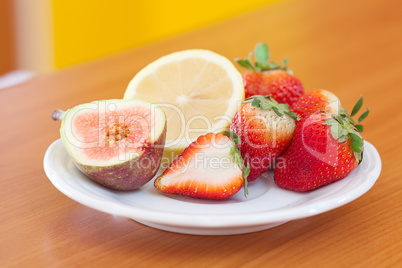 lemon, fig and strawberries on a plate