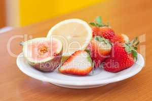 lemon, fig and strawberries on a plate