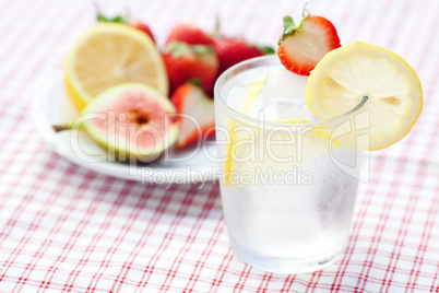 cocktail with ice,lemon, fig and strawberries on a plate