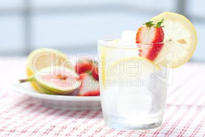 cocktail with ice,lemon, fig and strawberries on a plate
