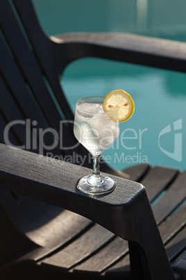 Swimming pool, lounge, a wine glass with ice, lemon and strawber