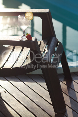 Swimming pool, lounge, a wine glass with ice, lemon and strawber