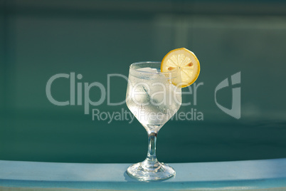 Swimming pool and a wine glass with ice and  lemon