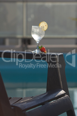 Swimming pool, lounge, a wine glass with ice, lemon and strawber