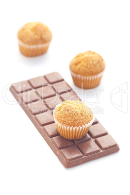 bar of dark chocolate and muffin isolated on white