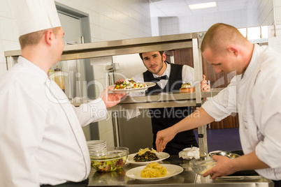 Professional kitchen cook prepare meal give waiter