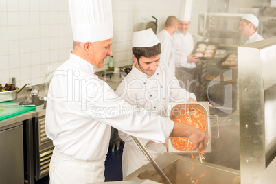 Two professional chefs cooking in kitchen