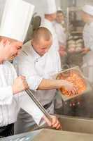 Two professional chefs cooking in kitchen