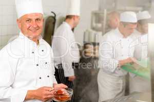 Professional kitchen smiling chef add spice food
