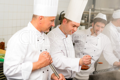 Two male cook work in professional kitchen