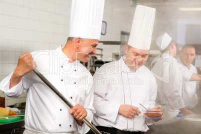 Two male cook work in professional kitchen