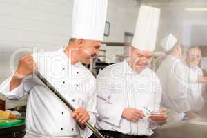 Two male cook work in professional kitchen