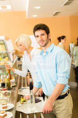 Business colleagues at cafeteria with serving tray
