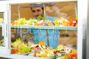 Cafeteria food display young man choose salad