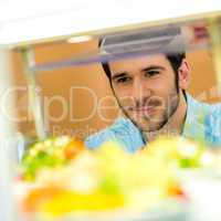 Cafeteria food display young man choose salad