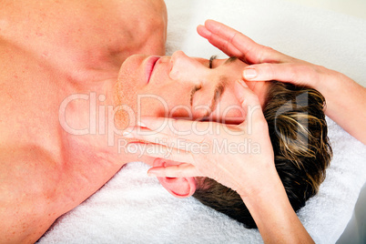 young man receives a face massage