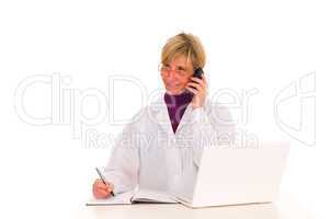female doctor at the desk with mobile and laptop