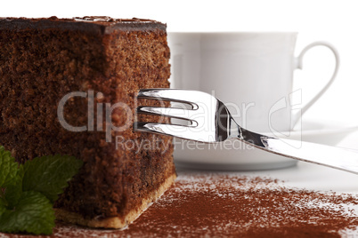 Schokoladenkuchen mit einer Gabel auf weißem Hintergrund